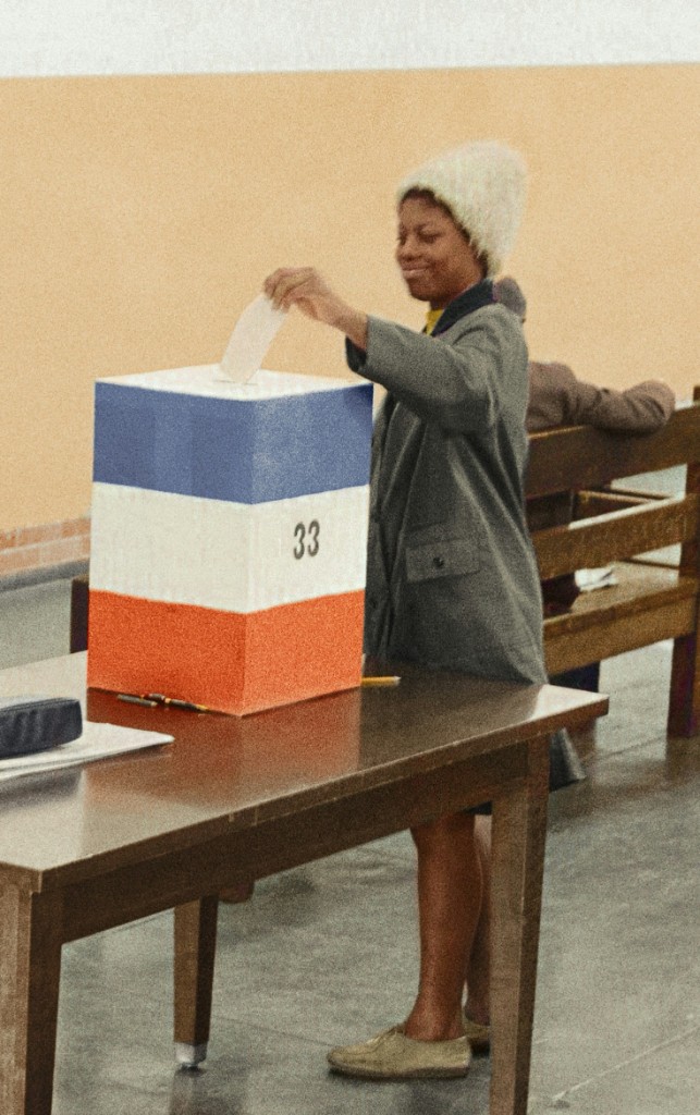 Young woman casting a vote into a ballot box